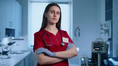 Modern bir dolapta ellerini çapraz yapmış ciddi bir kadın veterinere yakın durun. Doktor steteskoplu, rozetli ve tıbbi eldiven giyiyor. Yüksek kalite 4k görüntü