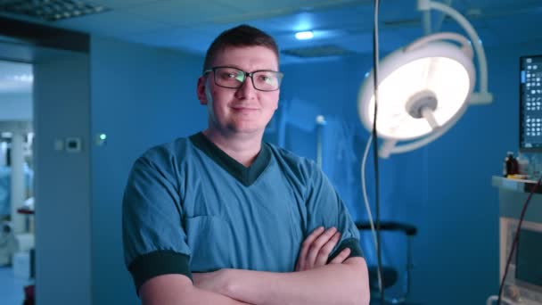 一位戴眼镜的兽医 面带微笑地看着摄像机 他身后有一个X光扫描仪 他是个了解自己工作领域的医学专家 — 图库视频影像
