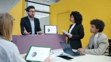 Modern ofis alanındaki bir toplantı için beyin fırtınası yapan genç profesyoneller. Duygusal CEO içeride çalışanlara yeni fikirleri açıklıyor. Yüksek kalite 4k görüntü