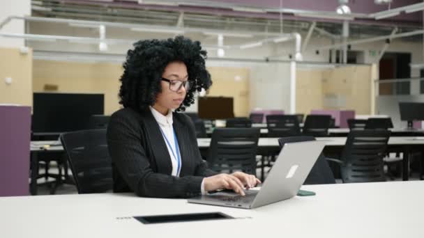 在办公室工作的戴着眼镜 穿着正装的非洲裔美国女人的近照 一个年轻女性专业人员在笔记本电脑上打字的肖像 高质量的4K镜头 — 图库视频影像