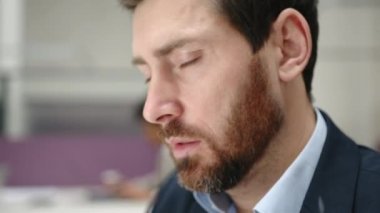 Dizüstü bilgisayara bakarken gözlüğü ayarlayan bir adamın yakın çekim görüntüsü. Yorgun satış müdürünün portresi gözlerini kapatıyor. Yüksek kalite 4k görüntü