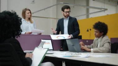 Modern ofis alanında çalışan bir grup genç profesyonel. Resmi giysiler içinde dost canlısı meslektaşlar yeni mali raporlar ve beyin fırtınası hakkında tartışıyorlar. Yüksek kalite 4k görüntü
