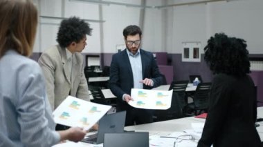 Modern ofis alanında çalışan beyaz ve Afrikalı erkek ve kadınlar. Takım elbiseli iş adamları yeni projeyi tartışıyor. Yüksek kalite 4k görüntü