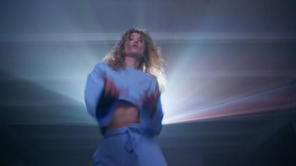 プロジェクターでミュージックビデオを見て 自宅で踊る幸せな若い女性 楽しさを持つ青いスーツのケアフリー女性 高品質4K映像 — ストック動画