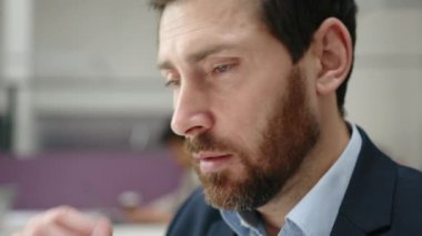 Modern ofis alanında bilgisayar üzerinde çalışan yetenekli erkek profesyonelin yakın plan çekimi. Raporunu yazan odaklanmış beyaz bir adamın portresi. Yüksek kalite 4k görüntü