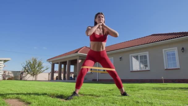 Γυναίκα Αθλητής Χρησιμοποιεί Ελαστική Ταινία Για Την Αντίσταση Νεαρή Καυκάσιος — Αρχείο Βίντεο