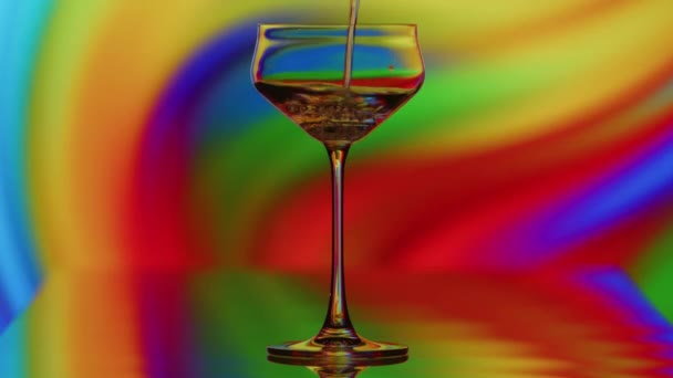 Das Klare Glas Wird Vor Einem Bunten Kurvigen Regenbogenhintergrund Gefüllt — Stockvideo