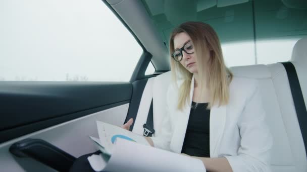 Geschäftsfrau Blättert Auf Dem Rücksitz Des Autos Unterlagen Großaufnahme Einer — Stockvideo