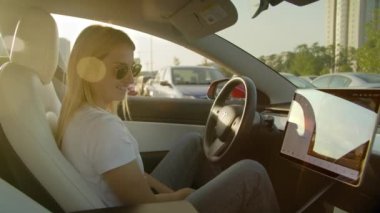 Kyiv, Ukrayna. Ağustos 2021. Otomatik park sistemi kullanarak Tesla Model 3 'ünü park eden bir kız. Modern yapay zeka teknolojisi bir arabanın kendi kendine park etmesine yardımcı olur. Yüksek kalite 4k görüntü