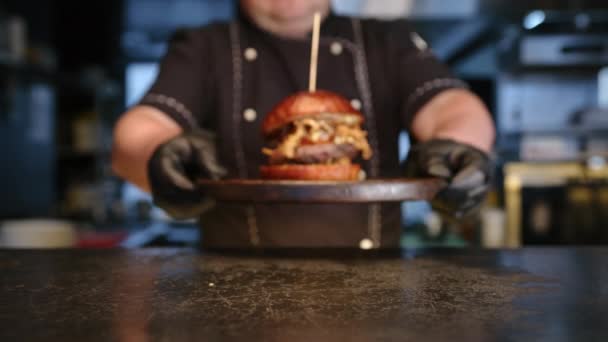 Der Koch Stellt Einen Frisch Zubereiteten Burger Auf Den Tisch — Stockvideo
