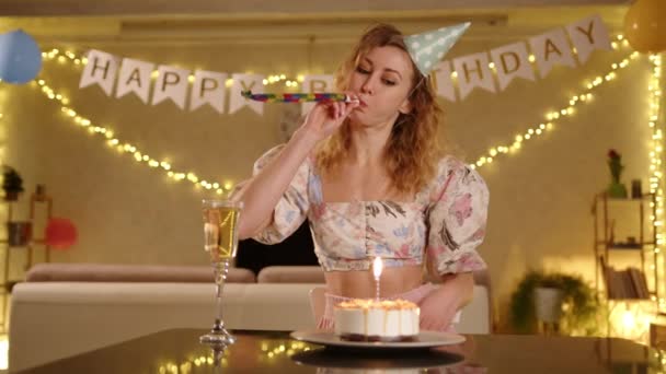 Kobieta Ładnej Sukience Imprezowym Czepku Dmuchająca Imprezkę Podczas Urodzinowej Uroczystości — Wideo stockowe