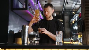 Barmen bar tezgahında alkollü kokteyl hazırlıyor. Yüksek kalite 4k görüntü