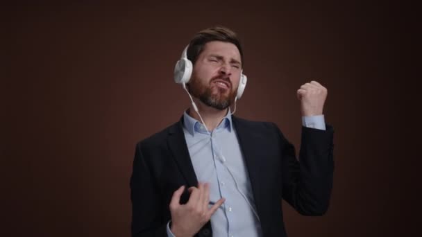Ein Mann Anzug Und Kopfhörer Der Luftgitarre Spielt Und Singt — Stockvideo