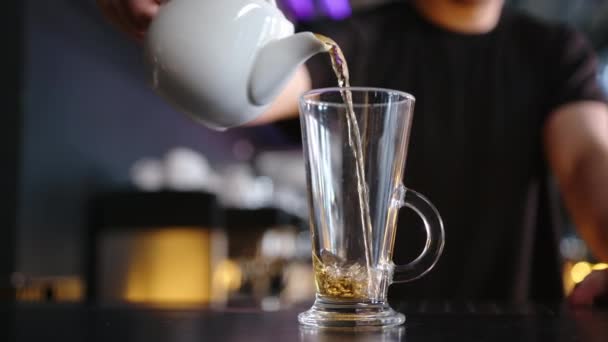 バーテンダーはカフェのカウンターのガラスに熱いお茶を注いだ 接近中だ スローモーション — ストック動画