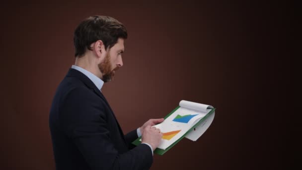 Muž Obleku Který Kontroluje Grafy Svém Tabletu Pak Otáčí Noviny — Stock video