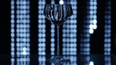 Düşen bir matrisin önünde duran cam kadehini arkaplandaki desen gibi temizleyin. Etkisi şarap bardağına yansıyor. Yüksek kalite 4k görüntü