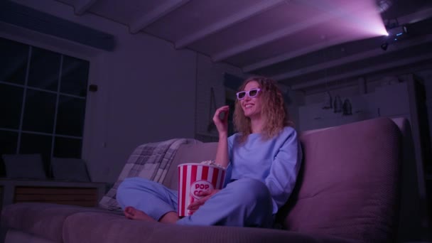快乐的高加索女人在家里吃爆米花 在放映机上看喜剧 一个笑着的女人的低角度镜头 高质量的4K镜头 — 图库视频影像
