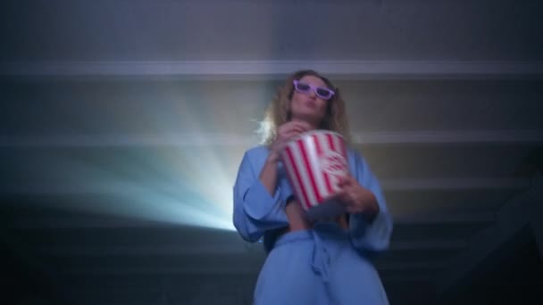 Веселая Белая Женщина Танцует Ест Попкорн Смотрит Музыкальные Клипы Проекторе — стоковое видео