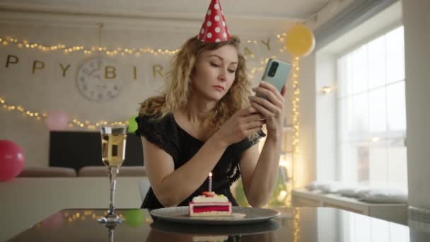 Vrouw Zit Voor Deur Van Verjaardagstaart Haar Telefoon Controleren Dan — Stockvideo