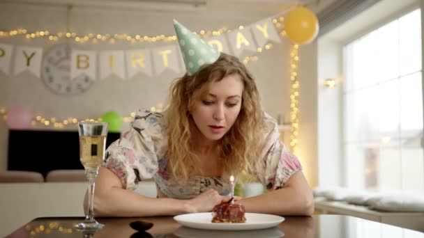 誕生日ケーキを見て 一口食べる前にろうそくを吹いている女性 彼女は視覚的に何かを悲しんでいる 高品質の4K映像 — ストック動画