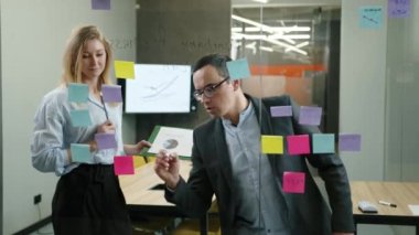 Kafkas erkek ve kadın portresi modern ofis alanında beyin fırtınası yapıyor. Yeni mali rapor hazırlayan başarılı girişimcilerin yakın plan görüntüsü. Yüksek kalite 4k görüntü