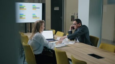 Modern ofis alanında iş birliği yapan erkek ve bayan meslektaşlar. Müşterilerle iş görüşmesi için hazırlanan genç profesyoneller. Yüksek kalite 4k görüntü