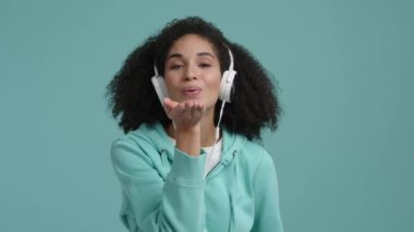 Mavi arka planda dans eden bir kadının portresi. Mutlu, neşeli bayan hava öpücüğü yolluyor. Yüksek kalite 4k görüntü