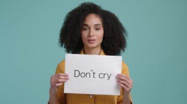 Güzel, esmer saçlı kız elinde beyaz bir kart tutuyor. Yüzünde iyimser bir ifade olan şefkatli genç bir kadının portresi. Yüksek kalite 4k görüntü