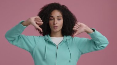 Etnik ve esmer saçlı üzgün bir kızın portresi. Koyu tenli bir kadın üzgün ve baş parmağını kaldırmış görünüyor. Yüksek kalite 4k görüntü