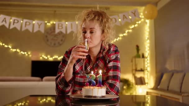 悲しい女性がシャンパングラスを手に取り それから小さな一口を取ります 誕生日ケーキのキャンドルは番号31を作成します 彼女はおそらく年をとるにつれて悩みそうだ 高品質4K映像 — ストック動画