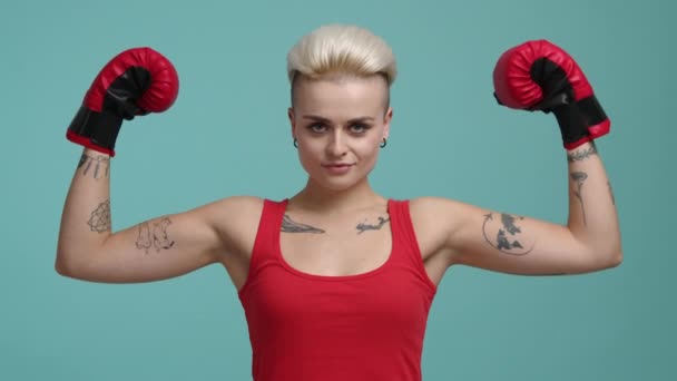 ウクライナ 2022年10月 前向きな表情をした金髪女のクローズアップ撮影 孤立したカラフルな背景で彼女の筋肉を示す美しい女の子 高品質4K映像 — ストック動画