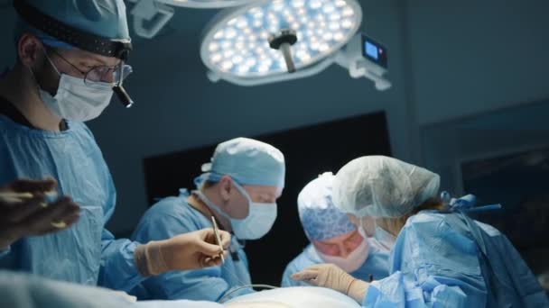 年轻医生使用缝合线进行整形手术时的外科缝纫过程 外科小组 靠在病人身上 在后台 高质量的4K镜头 — 图库视频影像