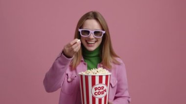 Film izlerken 3D gözlük takan tatlı bir kız. Lezzetli patlamış mısırın tadını çıkaran şık, genç bir kadının portresi. Yüksek kalite 4k görüntü