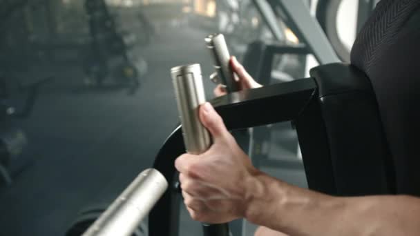体操の運動男による胸プレス機での運動のプロセス 男性の筋肉の手はハンドルを保持し 前後にそれらを押します 上半身のワークアウト 高品質4K映像 — ストック動画