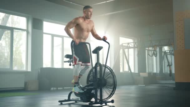 Jovem Desportista Bonito Com Tronco Muscular Funciona Bicicleta Sobre Pernas — Vídeo de Stock