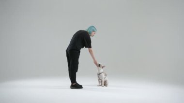 Fransız bulldog eğitiminde evet işareti kullanan dişi köpek eğitmeni. Marker köpek yavrusunun hareketlerinin doğru olduğunu ama bitmediğini anlamasına yardımcı oluyor. İkram olarak yiyecek. Yüksek kalite 4k görüntü