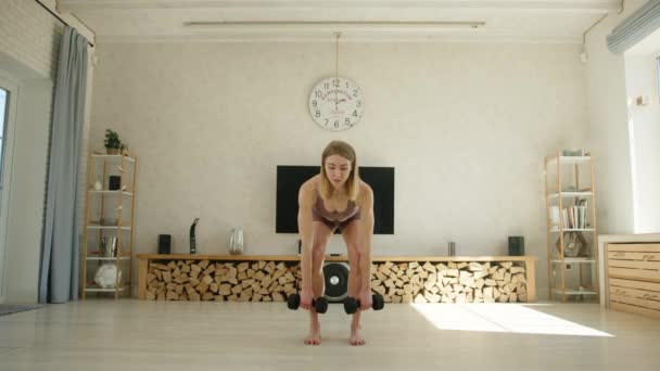 Seksi Sarışın Dambıl Kaldırma Hareketini Yan Hamlelerle Birleştiriyor Evde Egzersiz — Stok video