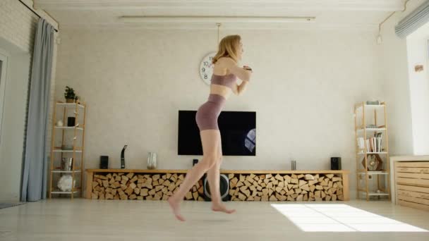 Profil Sportowej Blondynki Wykonującej Skokowe Skoki Ćwiczenia Domowe Kobieta Ćwiczy — Wideo stockowe