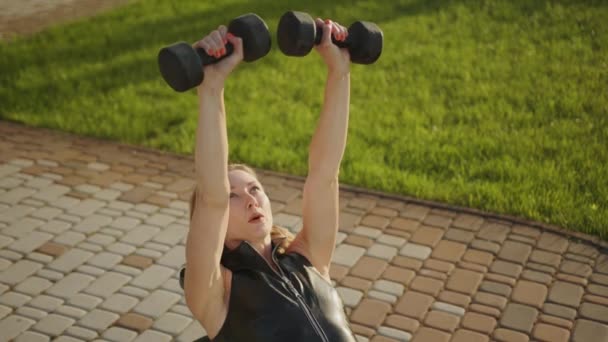 Střední Záběr Roztomilé Blonďaté Cvičení Činkami Ležícími Venku Lavičce Mladá — Stock video