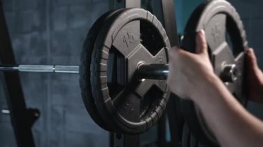  Yakışıklı vücut geliştirme elemanı spor salonunda halterle egzersiz yapmaya hazırlan, halter plakasını elinde tut. Yüksek kalite 4k görüntü