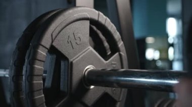  Yakışıklı vücut geliştirme elemanı spor salonunda halterle egzersiz yapmaya hazırlan, halter plakasını elinde tut. Yüksek kalite 4k görüntü