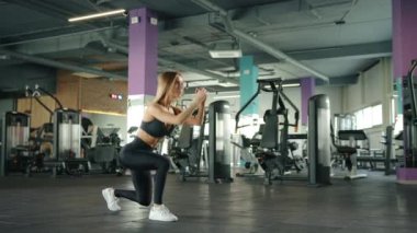 Spor kıyafetli genç bir kadın spor salonunda aerobik egzersizi yapıyor. Ağır çekim. Yüksek kalite 4k görüntü