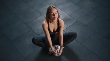 Spor kıyafetli, esneme hareketleri yapan, spor salonunda aerobik yapan genç bir kadın. Ağır çekim. Üst Manzara. Yüksek kalite 4k görüntü