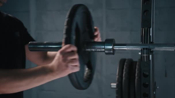 一个英俊健美的健美男准备在健身房里用杠铃做运动 把杠铃盘放在手里 高质量的4K镜头 — 图库视频影像