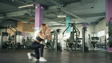 Spor kıyafetli genç bir kadın spor salonunda aerobik egzersizi yapıyor. Ağır çekim. Yüksek kalite 4k görüntü