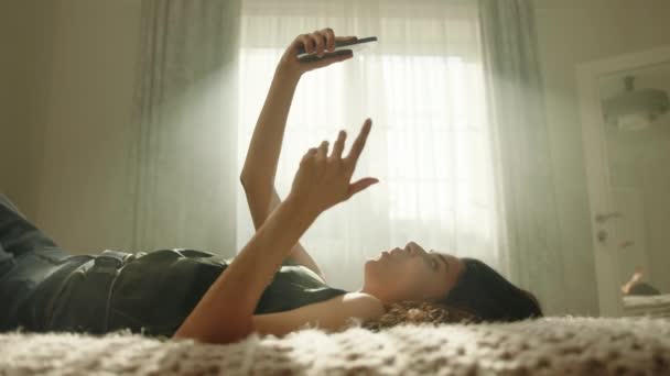 침대에 전화기의 비디오 링크를 의사소통하는 네트의 프로필 여자는 손에는 전화를 — 비디오
