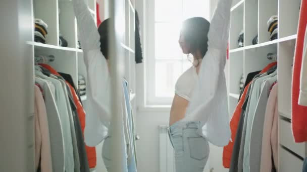 Piękna Uśmiechnięta Brunetka Dżinsach Białej Bluzce Zakłada Jasną Koszulę Garderobie — Wideo stockowe