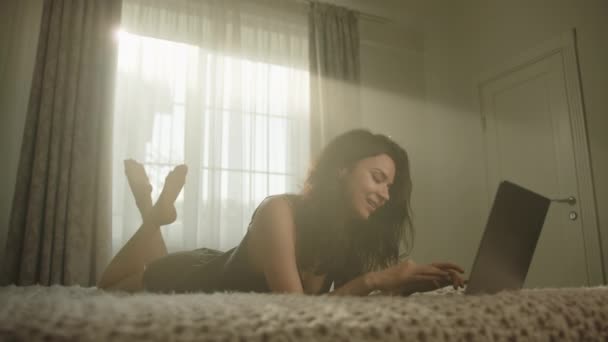 Ceria Brunette Lucu Mengetik Pada Laptop Berbaring Perut Tempat Tidur — Stok Video