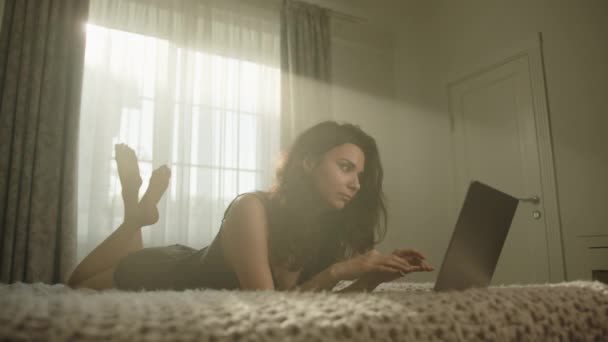 Bruneta Atractivă Relaxează Dormitor Luminat Razele Soarelui Tastând Laptop Tânăra — Videoclip de stoc
