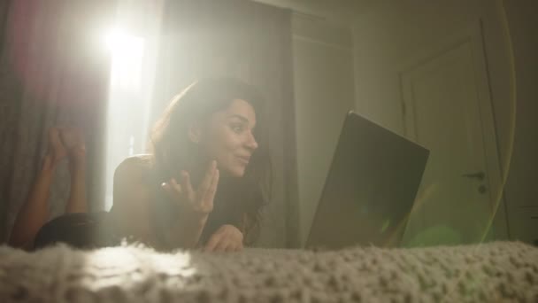 Feliz Atraente Morena Comunicando Link Vídeo Laptop Deitado Estômago Cama — Vídeo de Stock